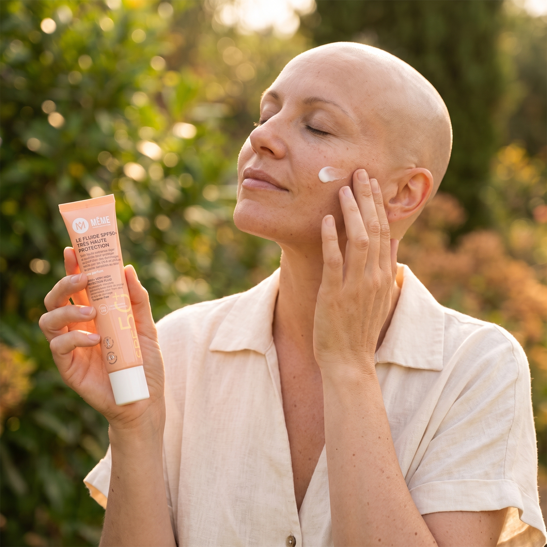Frau ohne Haare trägt die MÊME Sonnencreme LSF 50+ im warmen Sonnenlicht auf